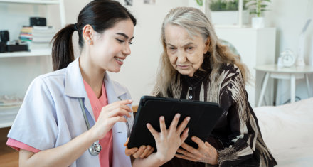 nurse and elderly reading